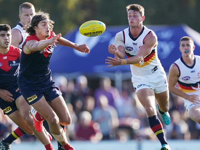 Matt Crouch of the Crows handballs from Luke Jackson of the Demons during the AFL Marsh Community Series pre-season match between the Melbourne Demons and Adelaide Crows at Casey Fields in Melbourne, Saturday, February 22, 2020. (AAP Image/Michael Dodge) NO ARCHIVING, EDITORIAL USE ONLY