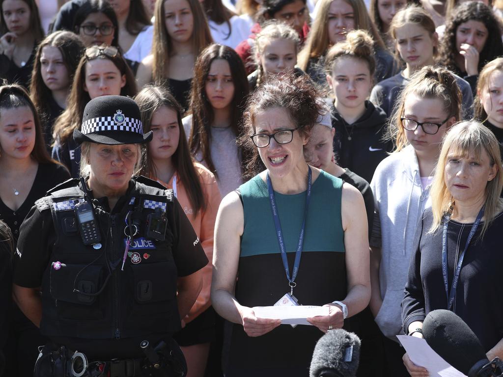 Co-Head teacher Anne Kennedy, centre, speaks to media as colleagues and pupils of teacher James Furlong hold a minute’s silence in his memory. Picture: Steve Parsons/PA via AP.