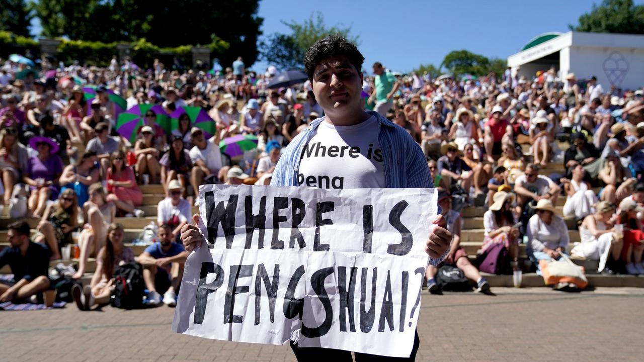 A protester holding a sign and wearing a T-shirt reading "where is Peng Shuai"