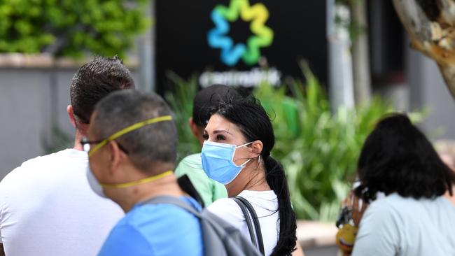 People wait in a long queue outside the Centrelink office in Southport on the Gold Coast. Picture: AAP