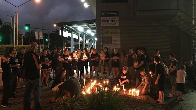 A vigil is held for Benjamin Suttie on the edge of the Woodridge park where he was stabbed.