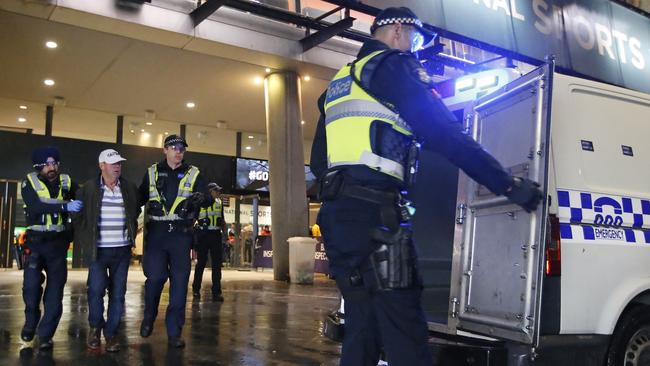 Police officers arrest a man outside the MCG. Picture: David Caird