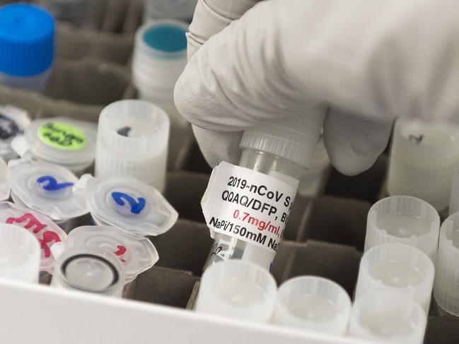 (FILES) In this file photo Dr. Nita Patel, Director of Antibody discovery and Vaccine development, lifts a vial with a potential coronavirus, COVID-19, vaccine at Novavax labs in Rockville, Maryland on March 20, 2020, one of the labs developing a vaccine for the coronavirus, COVID-19. - US authorities warned healthcare and scientific researchers May 13, 2020 that Chinese-backed hackers were attempting to steal research and intellectual property related to treatments and vaccines for COVID-19. Organizations researching the disease were warned of "likely targeting and network compromise by the People's Republic of China," a statement from the FBI and the Cybersecurity and Infrastructure Security Agency said."China's efforts to target these sectors pose a significant threat to our nations response to COVID-19," they said. (Photo by ANDREW CABALLERO-REYNOLDS / AFP)