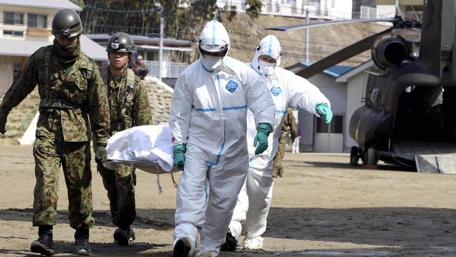 An injured worker is taken to hospital after the 2011 Fukushima nuclear reactor explosion). Picture: AFP