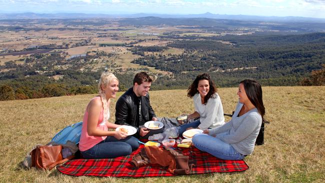 Picnickers at the hang gliding launching pad on top of Mount Tamborine. Melanie Thomas (left) and Bobby Bruce from Kirra on the Gold Coast entertained Italian visitors Silvia Gambasin and Alessia Zambelli-Titton (right) with prawn sandwiches while enjoying the awesome view. Pics Tim Marsden