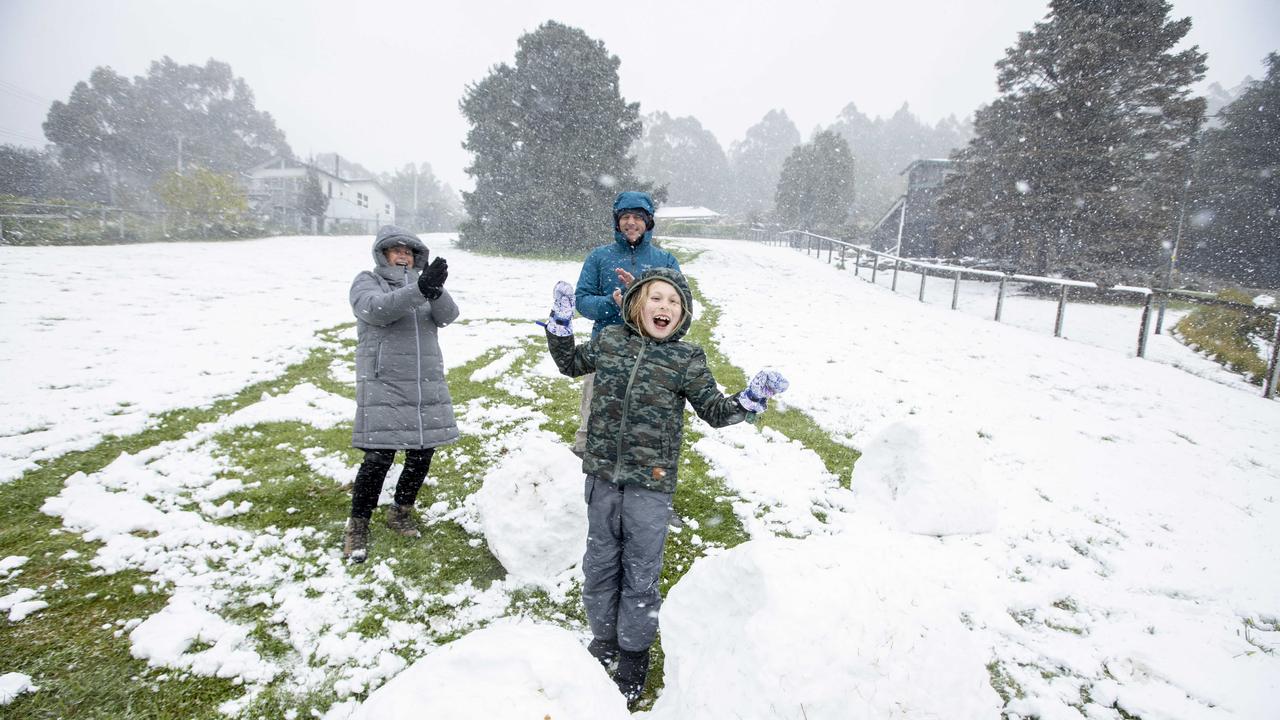 Snow down to around 200 metres around Hobart. Lizzy (8) celebrating the latest Spring snow at home with her parents. Picture Eddie Safarik