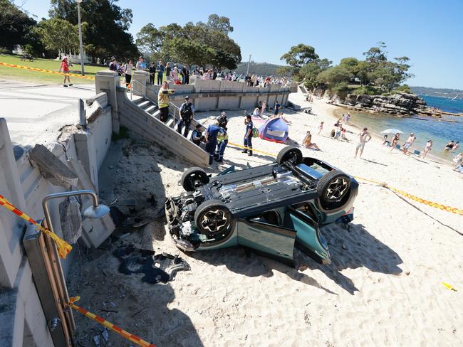 A car flipped over the wall at Sydney’s Balmoral Beach after a P-plater reportedly panicked while parallel parking and mistook the accelerator for the brake. Picture: Tim Pascoe