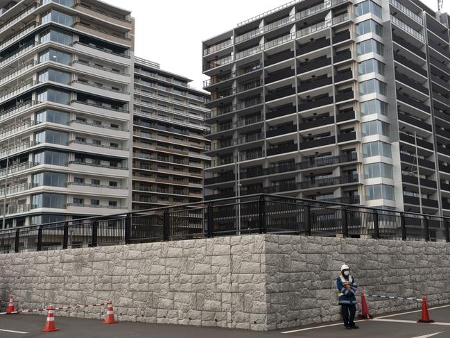 A guard stands in front of apartment buildings at the athletes' village for the Tokyo 2020 Olympics in Tokyo. Picture: AP Photo/Jae C. Hong, File