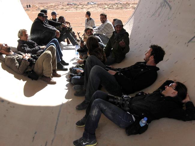 Addario, right, taking cover in a pipe in Libya with fellow New York Times photographers including Tyler Hicks, left, with whom she was kidnapped in 2011.