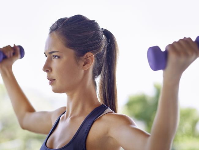 Shot of an attractive young woman working out with weights