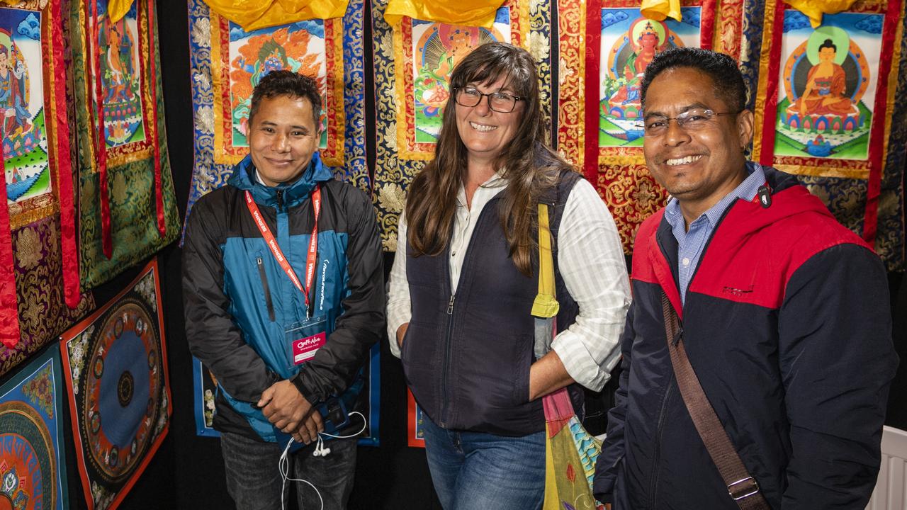 Abhaya Moktan (left) and Netra Chhatkuli of NS Handicraft Export show Debra Lynch the Nepalese thangkas on display at Craft Alive at the Goods Shed, Sunday, May 22, 2022. Picture: Kevin Farmer