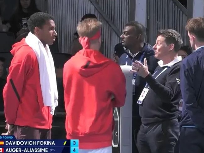 Felix Auger-Aliassime and Alejandro Davidovich Fokina engage in discussion with match officials.