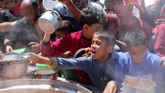 Palestinians queue for a portion of hot food at a charity kitchen at the Nuseirat refugee camp in the central Gaza Strip on Monday. Picture: AFP