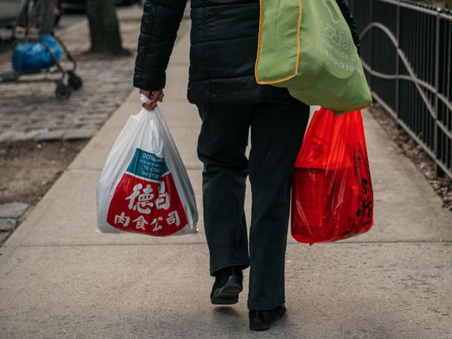 NEW YORK, NY - FEBRUARY 28: A woman walks while holding a plastic bag in Lower Manhattan on February 28, 2020 in New York City. New York City will institute a plastic bag ban on March 1st, demanding that businesses charge customers for using plastic bags in hopes of lowering landfill waste and promoting reusable bags among residents.  Scott Heins/Getty Images/AFP == FOR NEWSPAPERS, INTERNET, TELCOS & TELEVISION USE ONLY ==