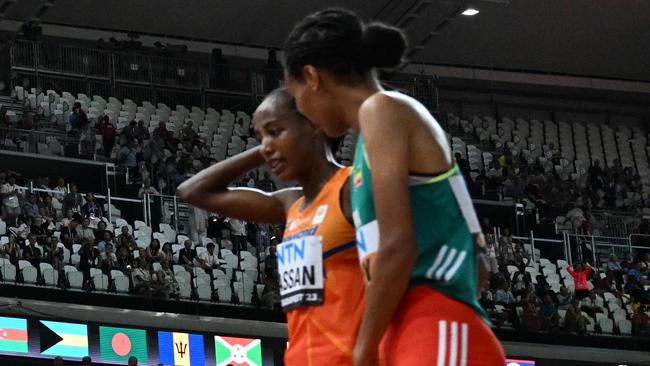 Ethiopia's Letesenbet Gidey embraces Netherlands' Sifan Hassan after the latter fell in the women's 10,000m final. (Photo by Jewel SAMAD / AFP)