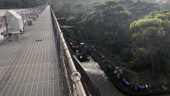 Water runs over the spillway below the dam wall at Manly Dam on Monday as authorities release water to allow for more flood storage in the dam reservoir at Manly Vale ahead of expected high rainfall in the coming three days. Picture: Jim O'Rourke