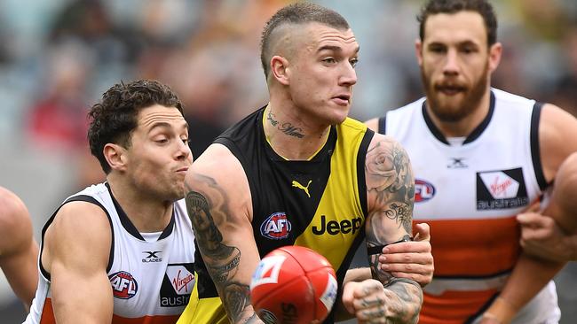 Dustin Martin (centre) is tackled by Josh Kelly.