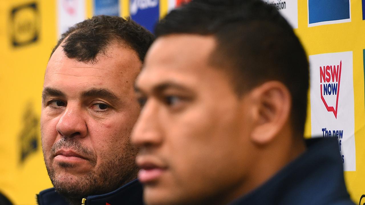 Wallabies coach Michael Cheika looks on as Israel Folau speaks.