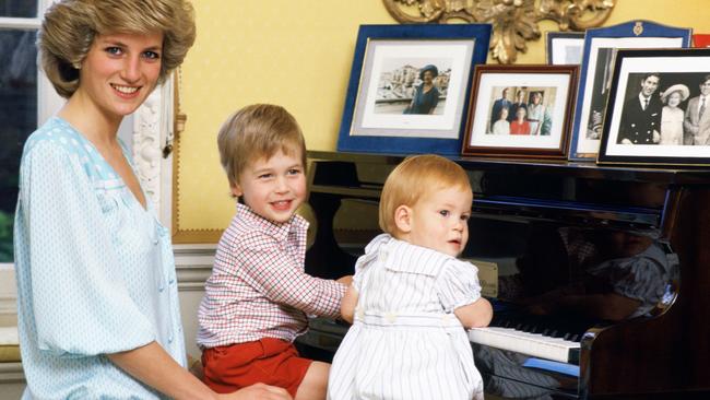 Diana, Princess of Wales with her sons, Prince William and Prince Harry, at the piano in Kensington Palace.