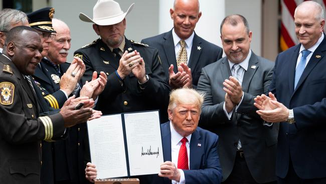 Donald Trump shows his signature on an Executive Order on Safe Policing for Safe Communities, earlier today. Picture: AFP.