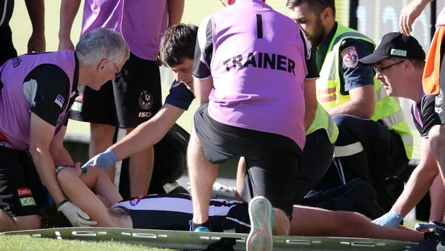 Tim Broomhead is helped onto a stretcher after breaking two bones in his leg. Picture: Michael Klein