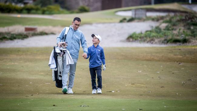 Junior golf champ Zac Wolfe and his dad Jeremy walk through Huntingdale Golf Club. Picture: Jake Nowakowski