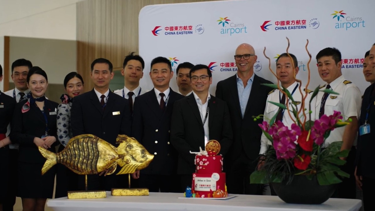 Pilots and crew gather to celebrate the return of China Eastern to Cairns with a cake cutting with Cairns Airport CEO Richard Barker. Photo: Supplied.