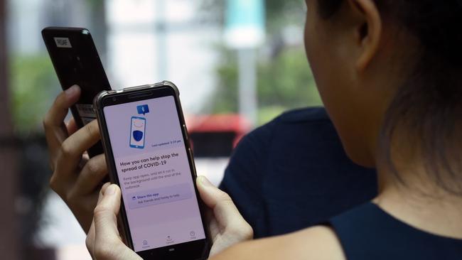 Government Technology Agency staff demonstrate Singapore's new contact-tracing smarthphone app in Singapore. The Australian Government is currently testing the technology. Picture: AFP