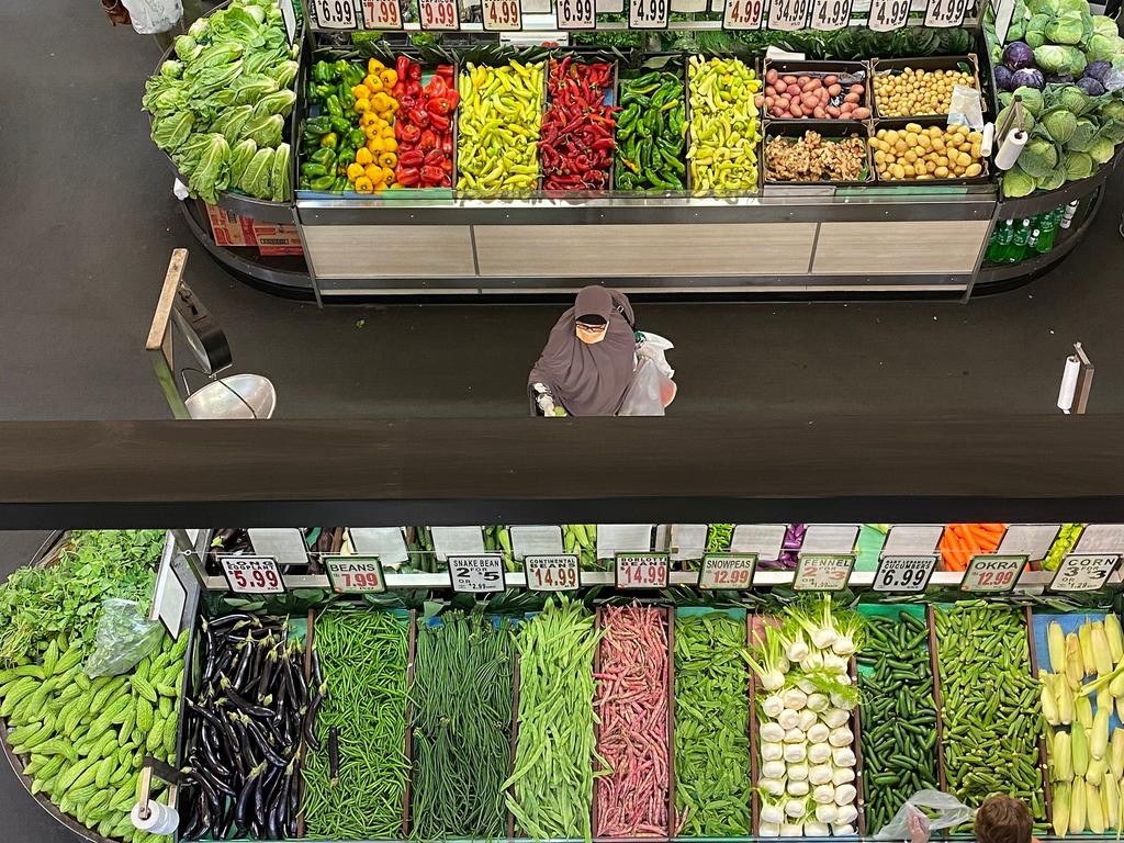 A customer wearing a face mask as a precaution against COVID-19 browses supermarket shelves by herself in Sydney. Picture: Saeed Khan/AFP