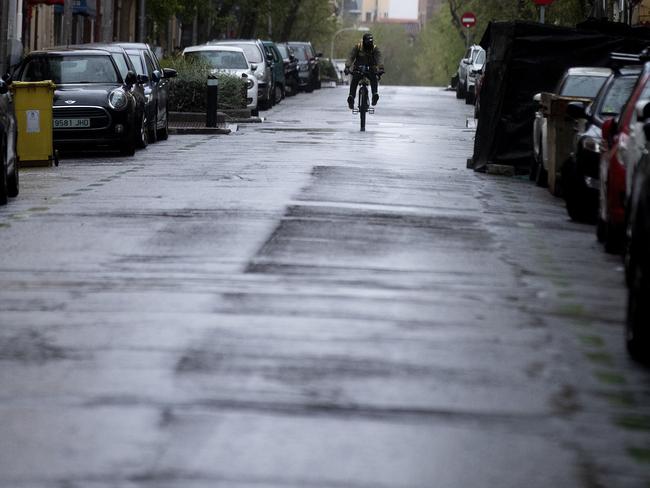 A takeaway food delivery rider rides down an empty street in Madrid, Spain. Picture: AP