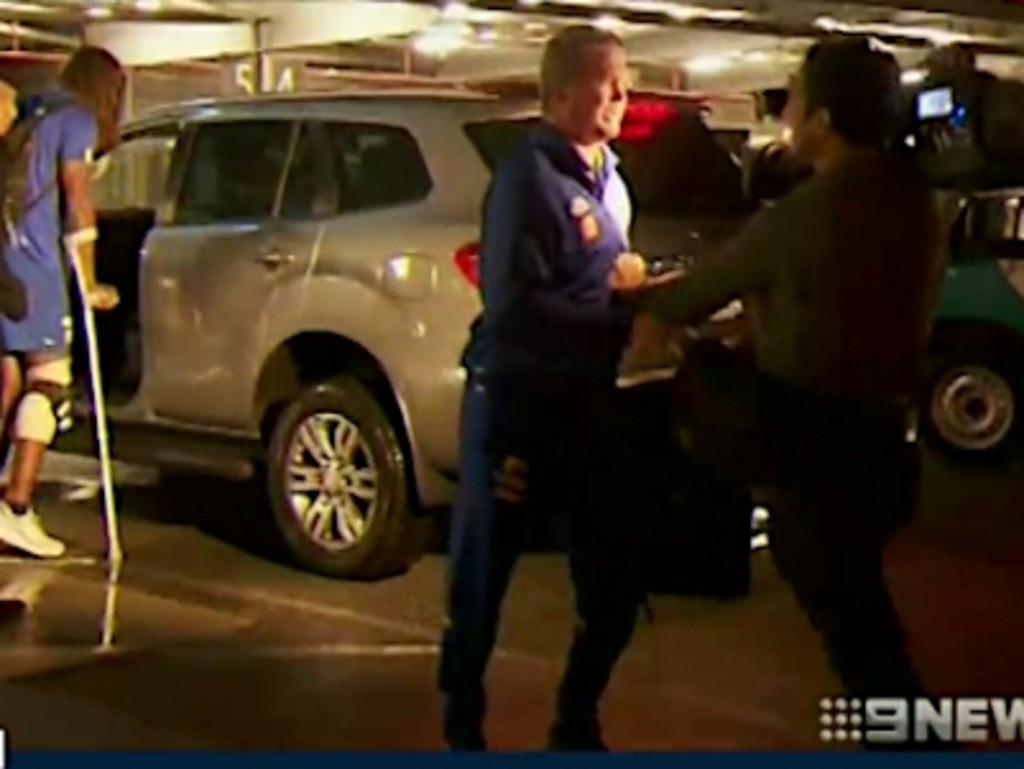 Nic Naitanui arrives back in Perth on crutches. West Coast Eagles official Peter Staples then turned on a cameraman who was filming from a distance.