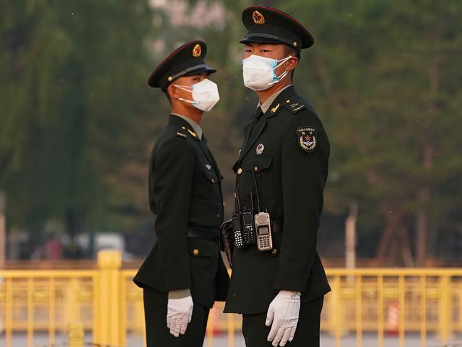 Two Chinese paramilitary policeman wears protective mask in Beijing. Picture: Getty Images