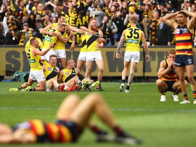 Tigers celebrate their victory as dejected Crows players hit the deck. Picture: Getty Images