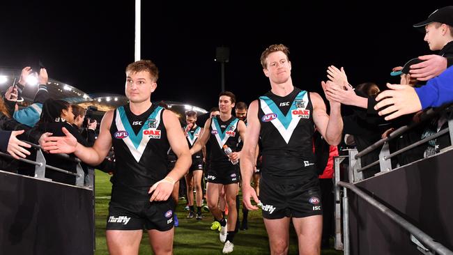 Ollie Wines and Tom Jonas lead their Power teammates off Adelaide Oval after their round 23 win over Fremantle. Picture: Mark Brake/Getty Images