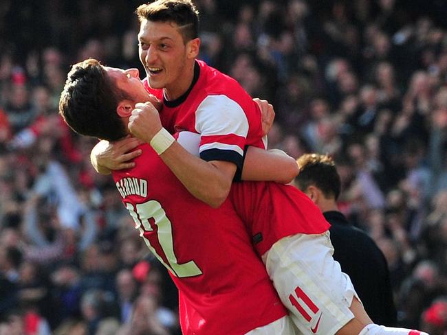 Arsenal's French striker Olivier Giroud (L) celebrates scoring the fourth goal with German midfielder Mesut Ozil (C) during the English FA Cup quarter final football match between Arsenal and Everton at the Emirates Stadium in London on March 8, 2014. Arsenal won 4-1. AFP PHOTO/GLYN KIRK RESTRICTED TO EDITORIAL USE. No use with unauthorized audio, video, data, fixture lists, club/league logos or "live" services. Online in-match use limited to 45 images, no video emulation. No use in betting, games or single club/league/player publications. Picture: Afp