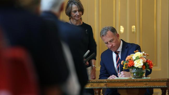 Premier Will Hodgman signs papers after taking the oath of office, watched by Governor Kate Warner. Picture: SAM ROSEWARNE