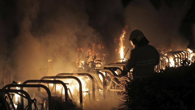 A firefighter puts extinguishes a fire set by protesters. Picture: AP