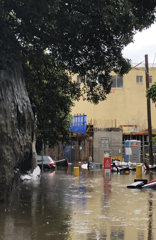 Cars and floating garbage bins after a heavy downfall in Kangaroo Lane in Manly on Tuesday, March 8, 2022. Picture: Jim O'Rourke