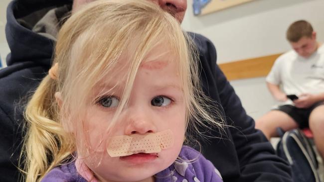 “We washed it out with saline, and put the bandaid on”, Paris Bregenhoj sitting with her father Mike Bregenhoj at the Royal North Shore hospital. Picture: Supplied.