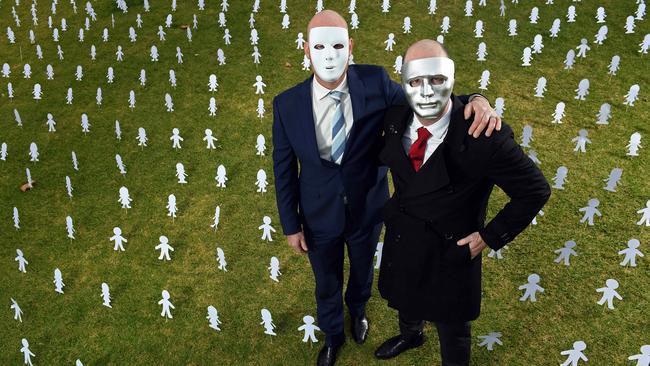 “A”, left, and his brother “B”, right, surrounded by paper cut outs symbolising the 1.4 million Australians who have endured child sex abuse. Picture: Tom Huntley