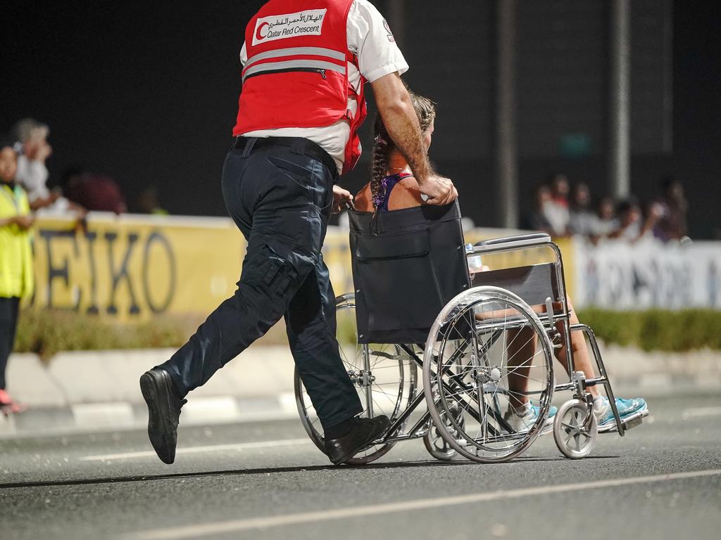 Paramedics bring an exhausted runner off the track at the athletics world championships in Qatar, 2019. Picture: Michael Kappeler/dpa