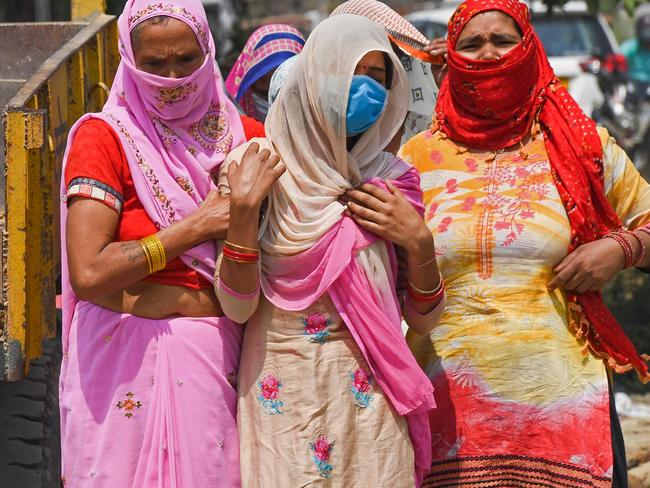 Relatives grieve as they arrive for the cremation of their loved one who died due to coronavirus in Moradabad. Picture: AFP