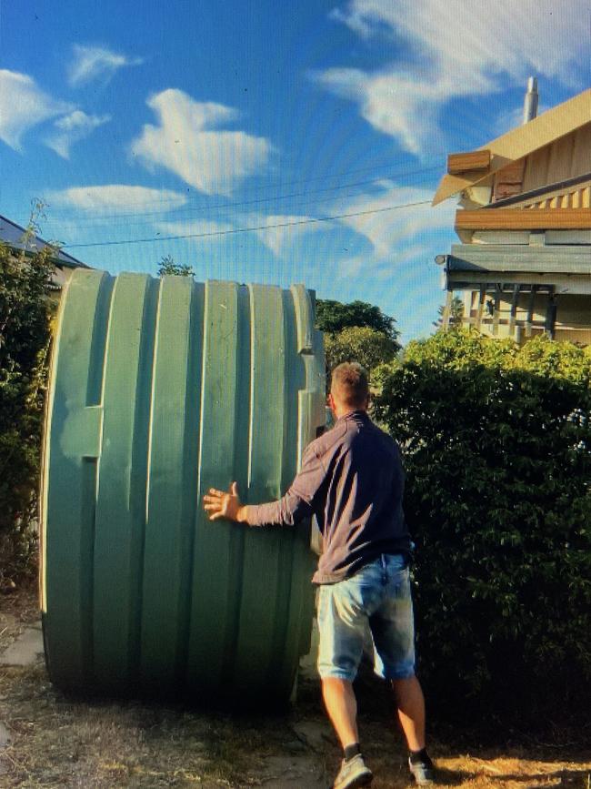 Malcolm Taylor pushes a water tank down the streets of Murtoa.