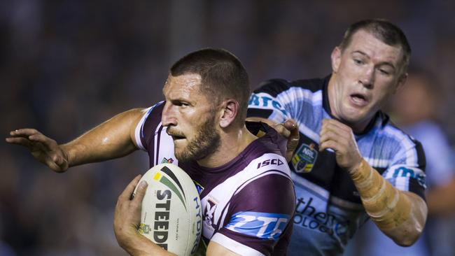Manly's Lewis Brown is tackled by Cronulla's Paul Gallen.