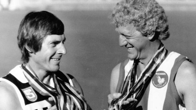 Ebert and North's Barrie Robran compare their Magarey Medal collections as a prelude to their roles in a testimonial cricket match for former SA Sheffield Shield captain Les Favell, April 3, 1987. Picture by staff photographer Neon Martin / The Advertiser.