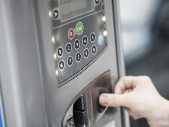 ESCAPE: Airport Parking, Lisa Mayoh -  Close up of a woman inserting coins into parking machine . Picture: iStock