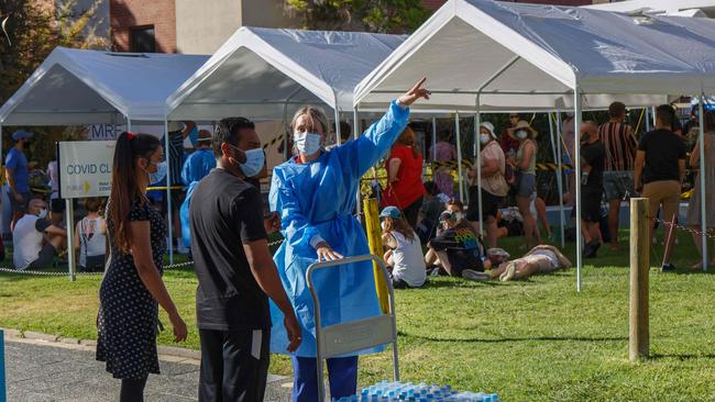 A health worker directs people wanting to be tested for COVID-19 to the end of the queue at Royal Perth Hospital in Perth. Picture: AFP.