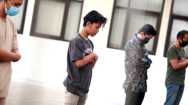 ‘Not scared’ … vaccine volunteer Karyana prays before receiving his vaccine injection this week. Picture: Agvi Firdaus