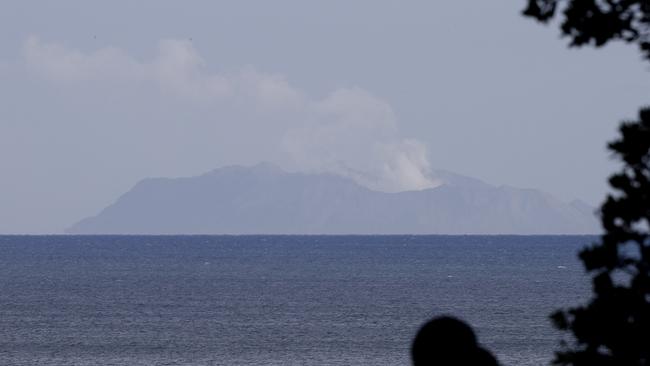 A man watches as a plume of steam is seen above White Island the coast of Whakatane on December 10. Picture: AP