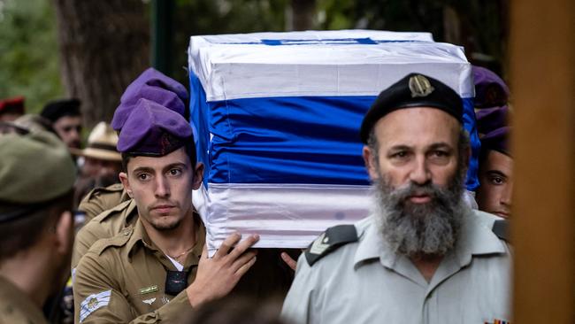 Israeli soldiers carry the casket of a fellow soldier during a funeral.